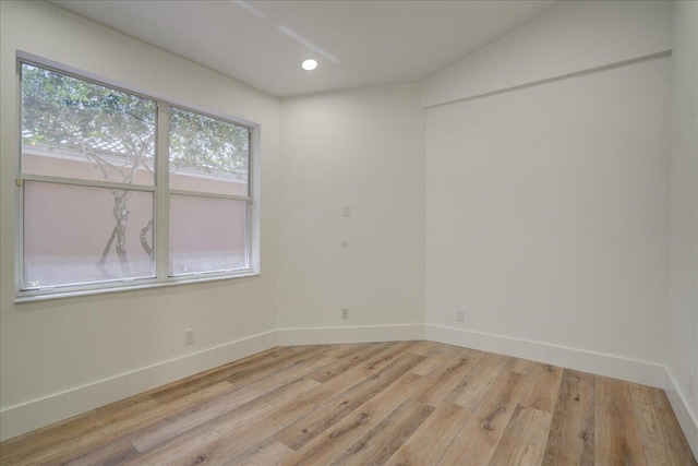 unfurnished room featuring vaulted ceiling and light hardwood / wood-style floors