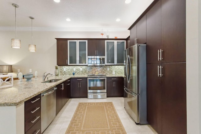 kitchen featuring kitchen peninsula, appliances with stainless steel finishes, tasteful backsplash, sink, and decorative light fixtures