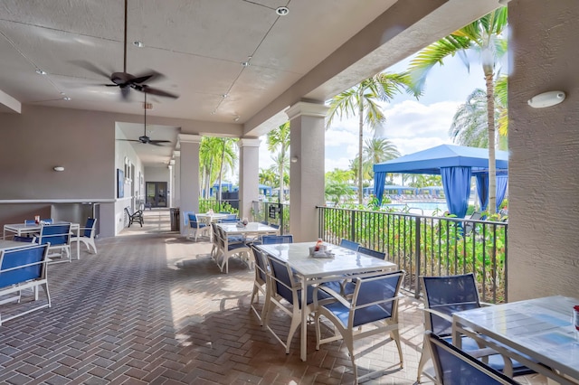 view of patio with a fireplace and ceiling fan