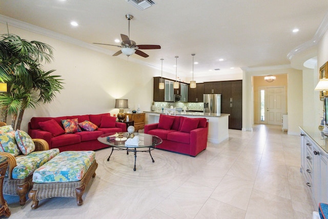 living room with ceiling fan and ornamental molding