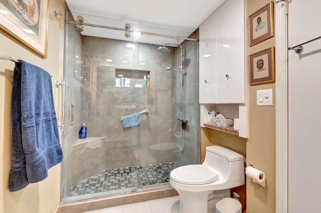 bathroom featuring tile patterned flooring, toilet, and a shower with door