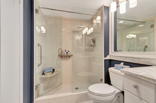 bathroom with tile patterned flooring, vanity, an enclosed shower, and toilet