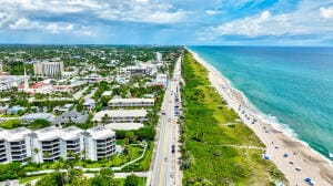 birds eye view of property featuring a water view and a beach view