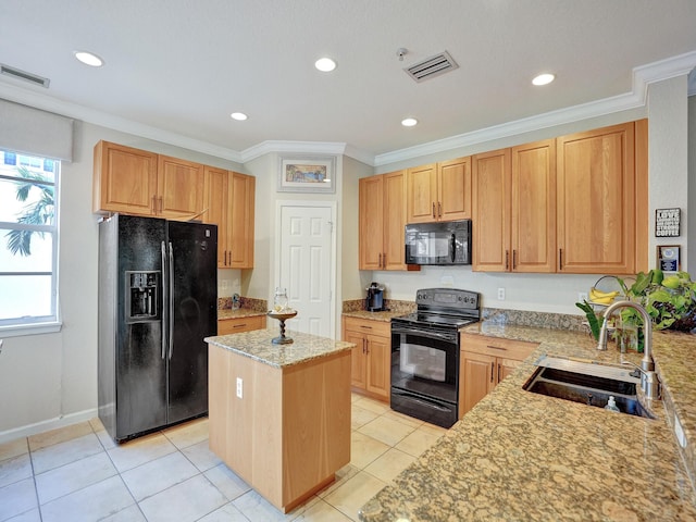 kitchen with sink, a center island, light stone counters, light tile patterned flooring, and black appliances