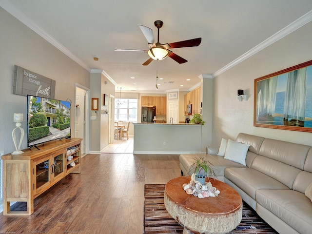 living room with hardwood / wood-style flooring, ceiling fan, and crown molding