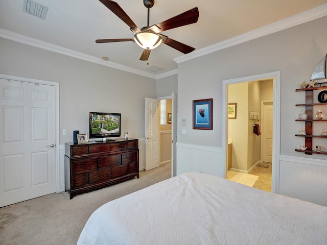 bedroom with connected bathroom, light carpet, crown molding, and ceiling fan