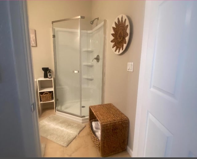 bathroom with tile patterned floors and a shower with door