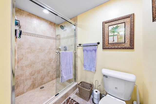 bathroom with a shower with door and toilet