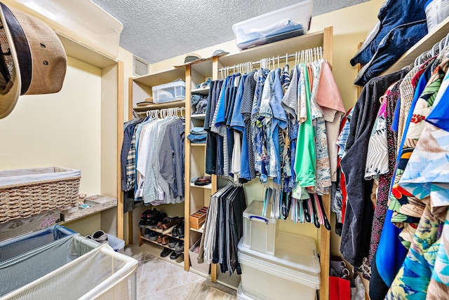 walk in closet with light tile patterned floors