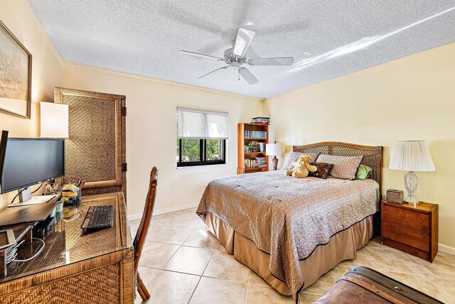 bedroom with ceiling fan, a textured ceiling, and light tile flooring