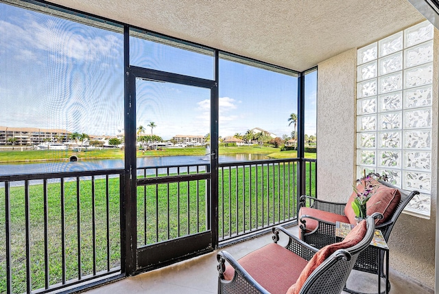 sunroom featuring a water view