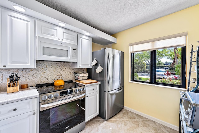 kitchen with appliances with stainless steel finishes, tasteful backsplash, and white cabinetry