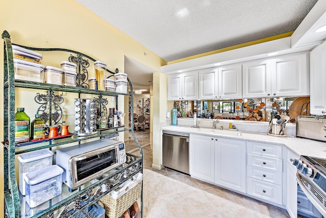 kitchen with stainless steel appliances, white cabinets, a textured ceiling, and light tile flooring