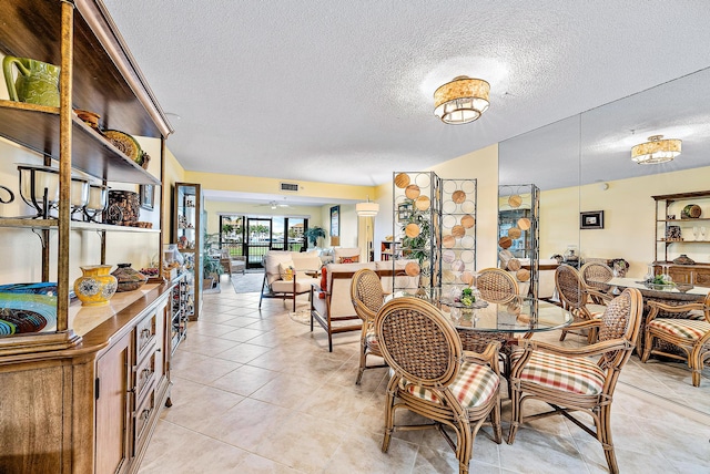 tiled dining area with a textured ceiling