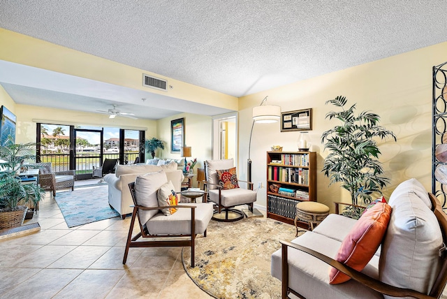 living room featuring a textured ceiling, ceiling fan, and tile flooring