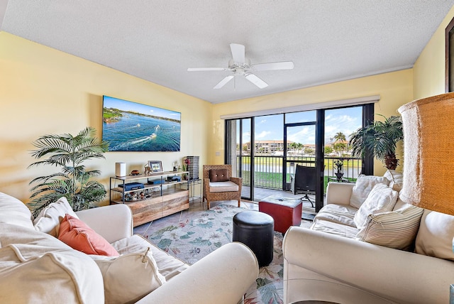 living room featuring a textured ceiling and ceiling fan