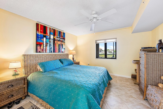 tiled bedroom with ceiling fan and a textured ceiling