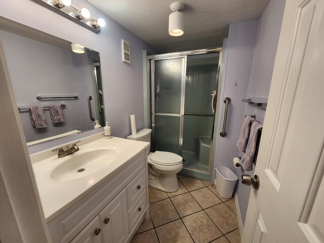 bathroom with vanity, tile patterned floors, toilet, a textured ceiling, and a shower with shower door