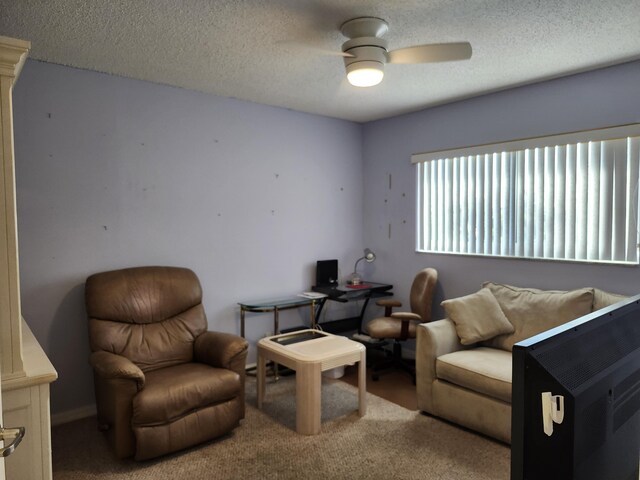 carpeted living room with ceiling fan and a textured ceiling