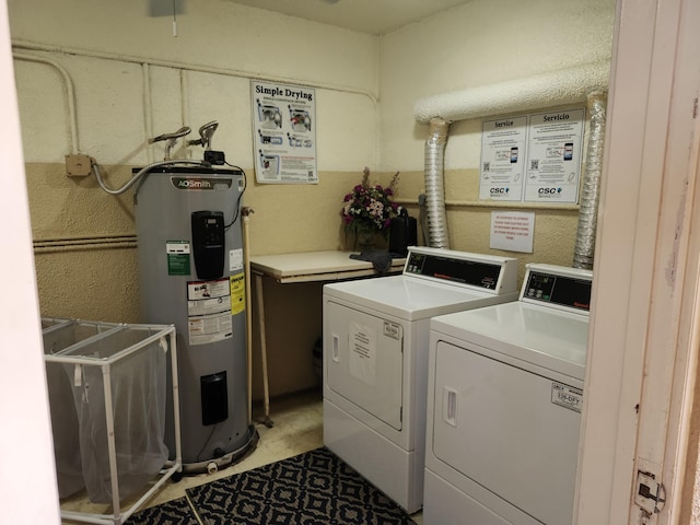 laundry room with water heater and washer and dryer