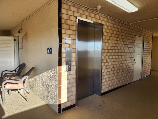 corridor featuring elevator and concrete floors