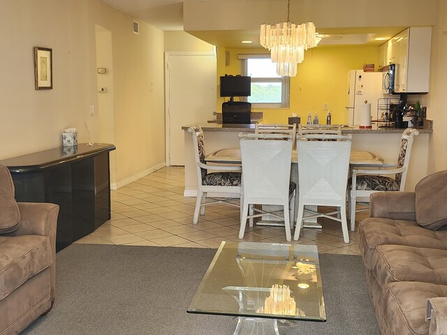 dining space with a notable chandelier and light tile patterned floors