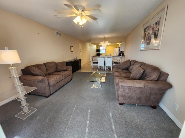 living room with dark carpet and ceiling fan with notable chandelier