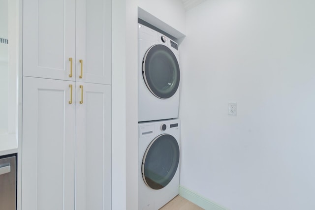 laundry area featuring stacked washer / drying machine