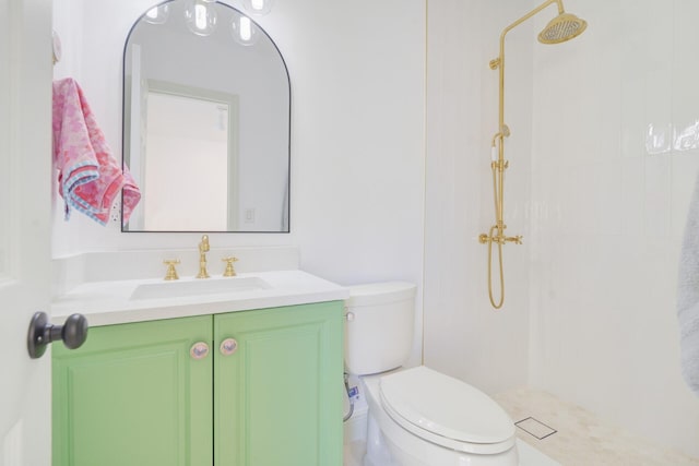 bathroom with tiled shower, vanity with extensive cabinet space, and toilet