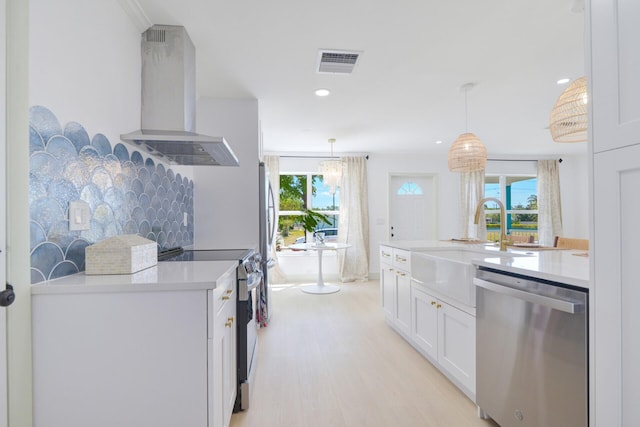 kitchen featuring plenty of natural light, electric stove, wall chimney range hood, and dishwasher