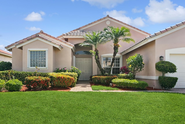 mediterranean / spanish-style house with a garage and a front lawn