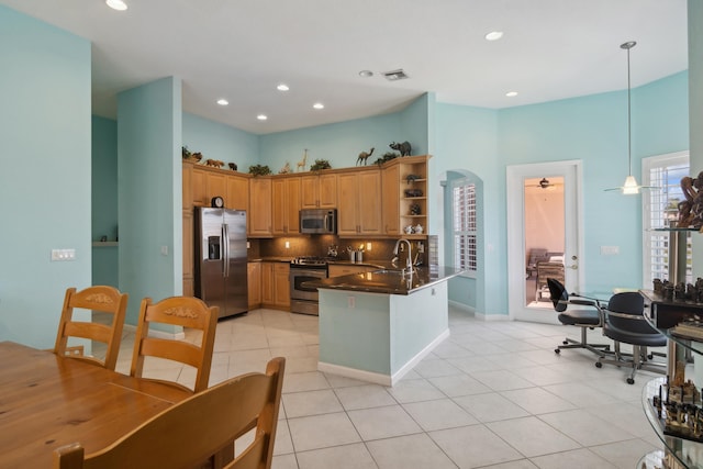 kitchen with light tile floors, backsplash, stainless steel appliances, kitchen peninsula, and pendant lighting