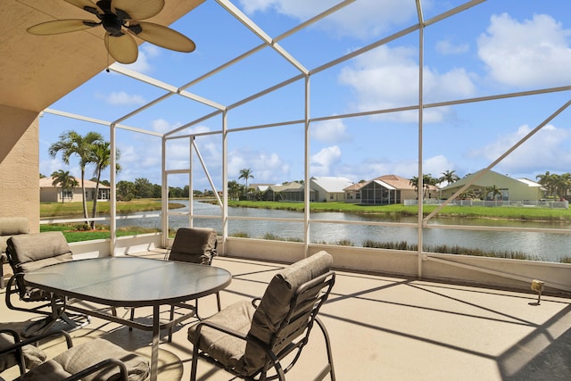 unfurnished sunroom featuring ceiling fan and a water view