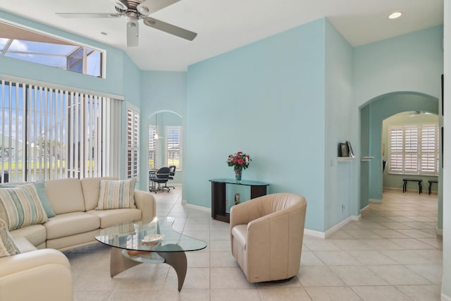 living room featuring a wealth of natural light, high vaulted ceiling, ceiling fan, and light tile flooring