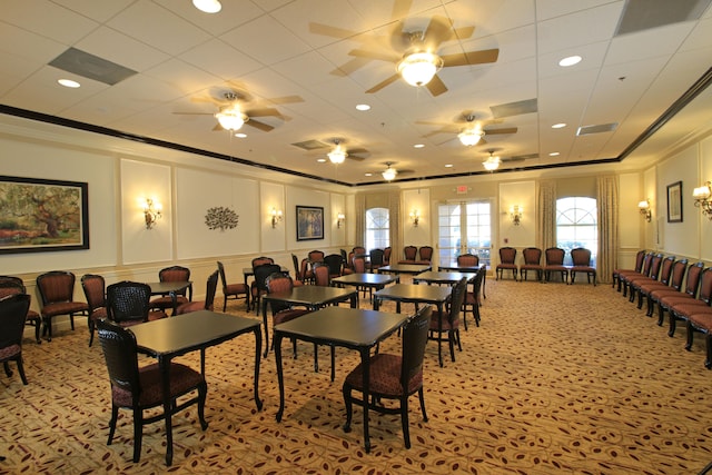 dining space with light colored carpet, ornamental molding, and ceiling fan