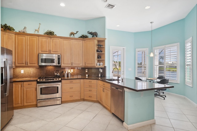 kitchen featuring sink, backsplash, light tile floors, and stainless steel appliances