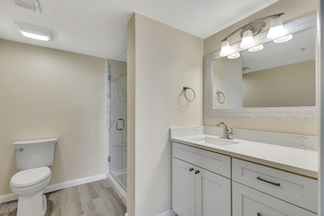 bathroom featuring hardwood / wood-style floors, vanity, an enclosed shower, and toilet