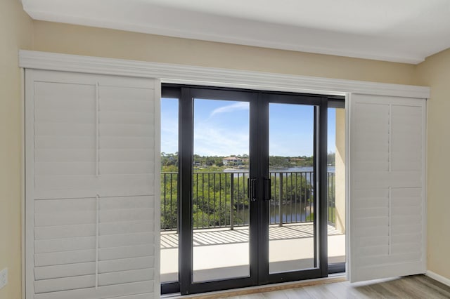 doorway featuring a water view and light wood-type flooring