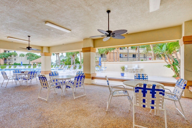 view of terrace featuring a community pool and ceiling fan