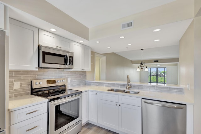 kitchen featuring backsplash, stainless steel appliances, light hardwood / wood-style floors, white cabinetry, and sink