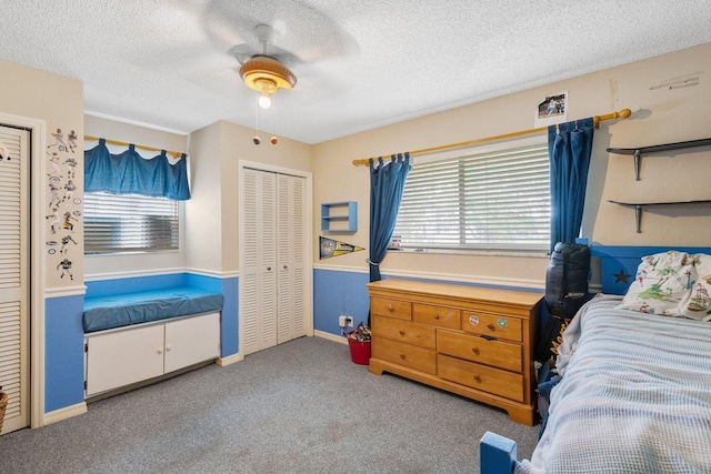 carpeted bedroom with ceiling fan, a closet, and a textured ceiling