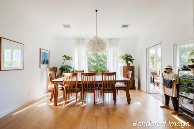 dining room with a notable chandelier, a wealth of natural light, and light hardwood / wood-style flooring