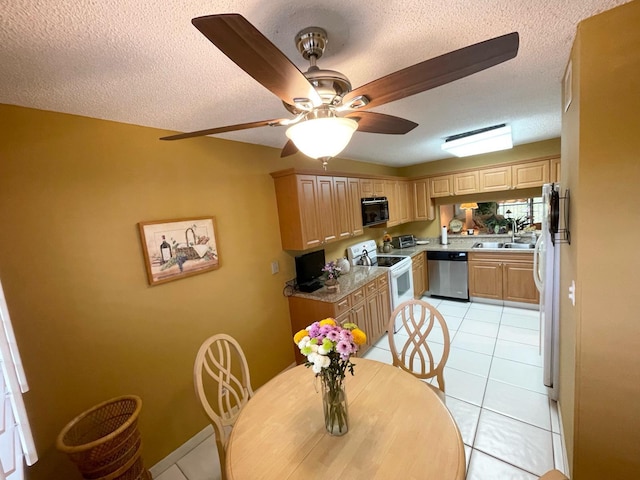 dining room with a textured ceiling, sink, ceiling fan, and light tile floors