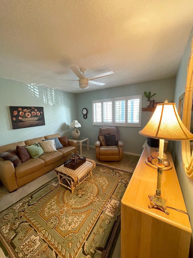 living room featuring ceiling fan and a textured ceiling