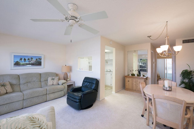 carpeted living room with ceiling fan with notable chandelier and sink