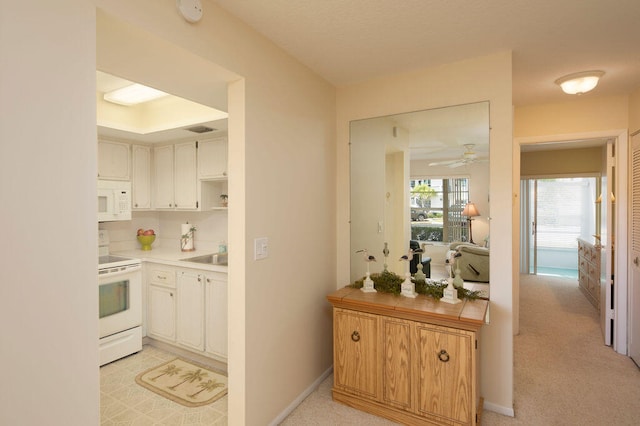 kitchen featuring white cabinets, light carpet, white appliances, and ceiling fan