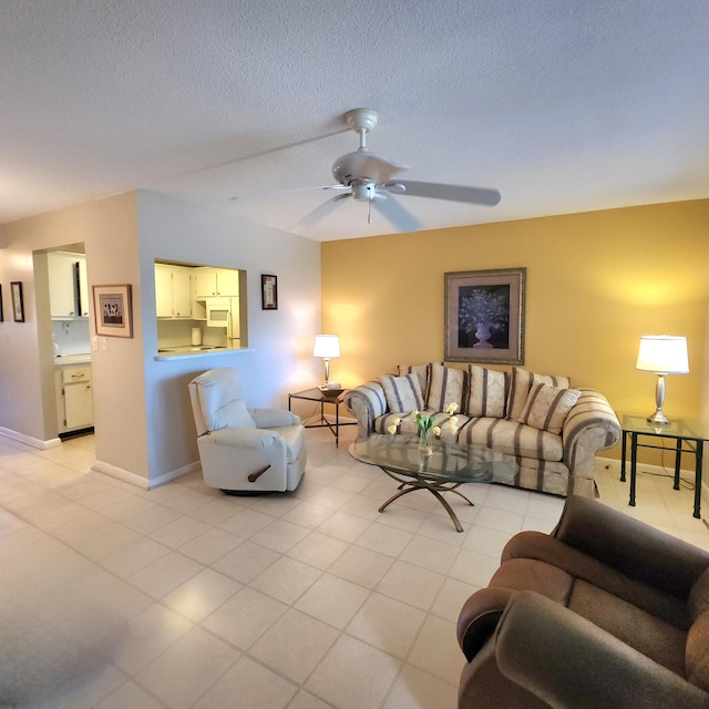 living room with a textured ceiling and ceiling fan