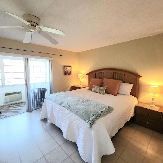 bedroom with ceiling fan, access to exterior, a textured ceiling, and a wall unit AC