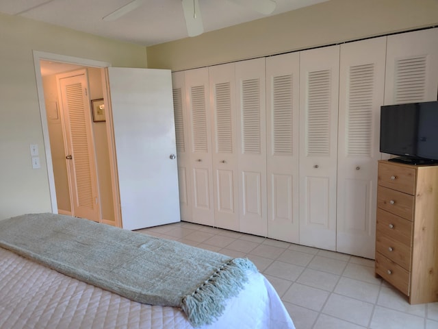 tiled bedroom featuring ceiling fan and a closet