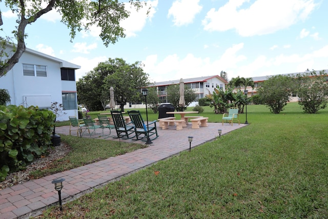 view of home's community featuring a lawn and a patio area